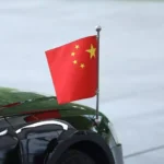 Ein schwarzes Auto mit kleiner chinesischer Flagge auf der Karosserie.