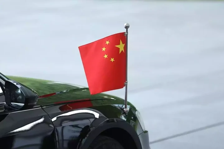 Ein schwarzes Auto mit kleiner chinesischer Flagge auf der Karosserie.
