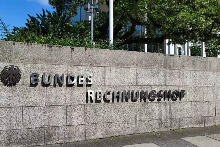 Schild mit dem Schriftzug „Bundesrechnungshof“ an einer Steinmauer vor einem Verwaltungsgebäude.