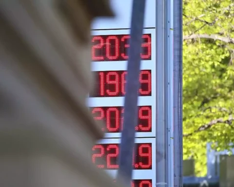 Digitale Kraftstoffpreisanzeige an einer Tankstelle vor grünem Hintergrund.