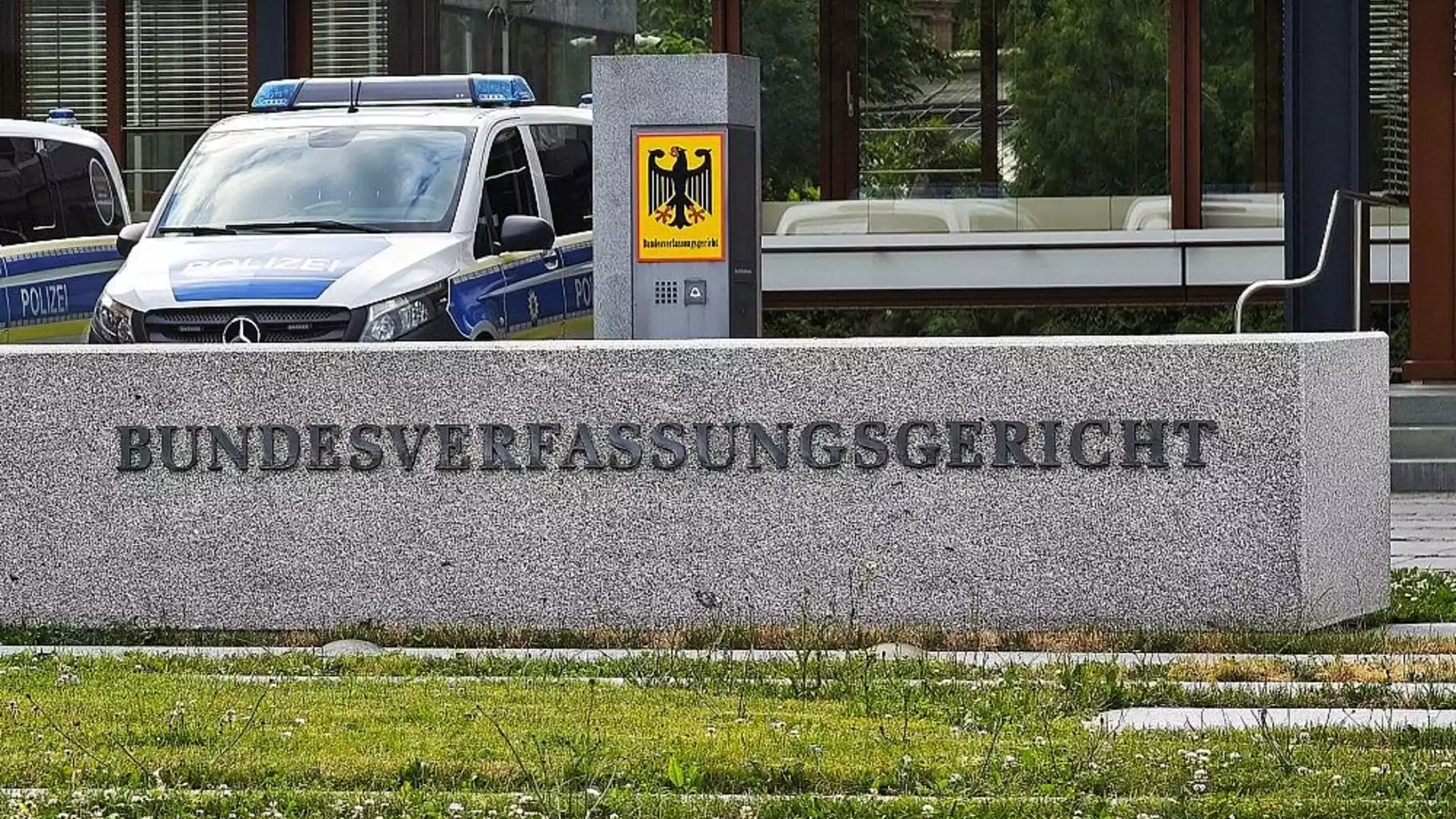 Eingang des Bundesverfassungsgerichts in Karlsruhe mit Polizeifahrzeug davor.