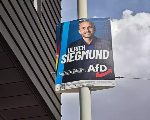 AfD-Wahlplakat mit dem Porträt von Ulrich Siegmund an einem Mast neben einem Gebäude.