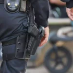 Polizisten mit Ausrüstung und Holster stehen nebeneinander.