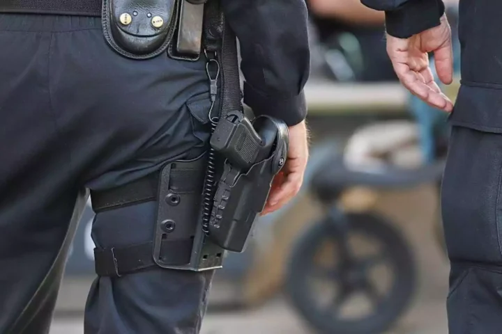 Polizisten mit Ausrüstung und Holster stehen nebeneinander.