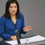 Eine Frau im blauen Blazer spricht am Rednerpult im Bundestag.