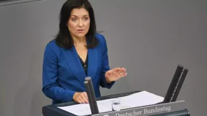 Eine Frau im blauen Blazer spricht am Rednerpult im Bundestag.