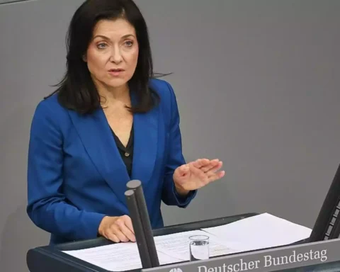 Eine Frau im blauen Blazer spricht am Rednerpult im Bundestag.