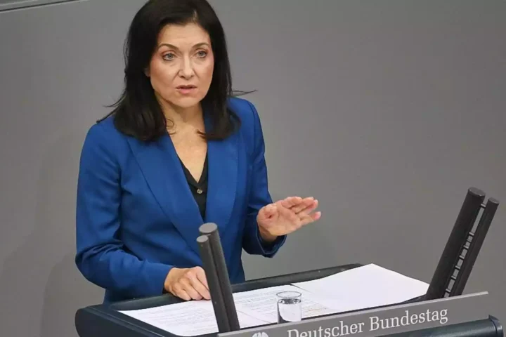 Eine Frau im blauen Blazer spricht am Rednerpult im Bundestag.