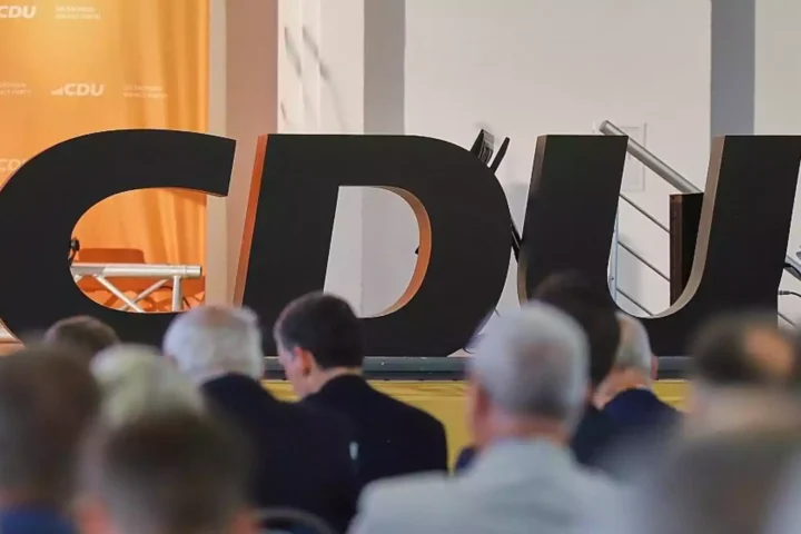 Große CDU-Buchstaben vor einer Bühne mit Publikum im Vordergrund.