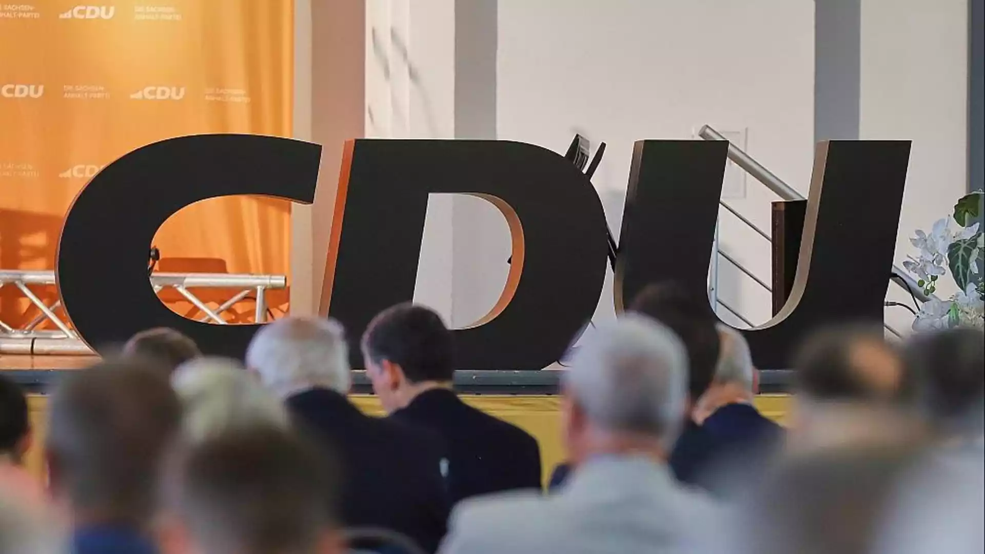 Große CDU-Buchstaben vor einer Bühne mit Publikum im Vordergrund.