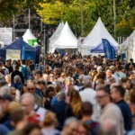 Menschenmenge zwischen Festival- und Informationszelten im Freien