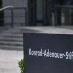 Schild der Konrad-Adenauer-Stiftung in Berlin vor einem Gebäude.
