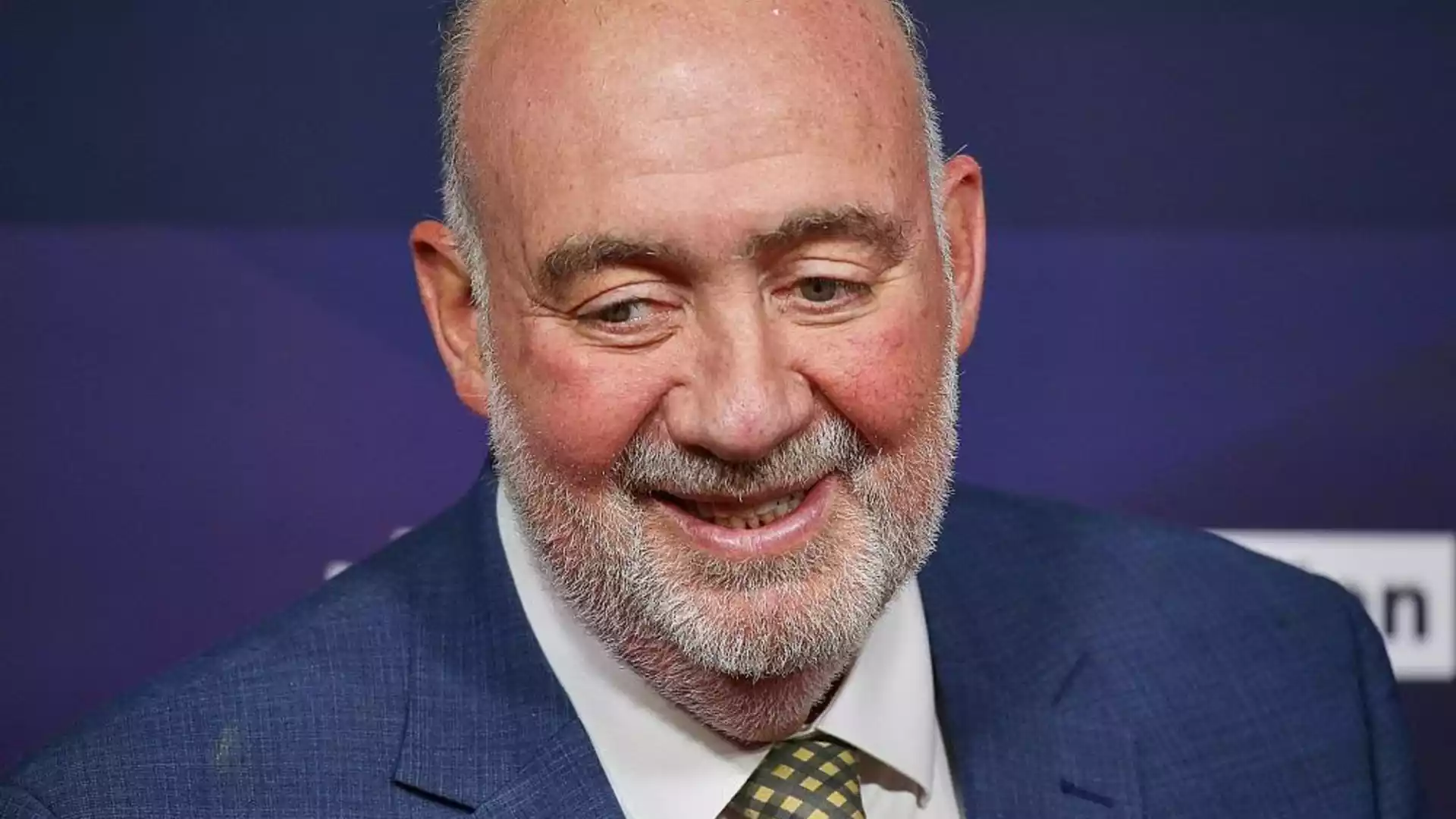 Prosor wirft Deutschland und Europa gefährliche Kurzsichtigkeit vor 1 Porträt eines älteren Mannes im blauen Anzug mit grauem Bart vor violettem Hintergrund.
