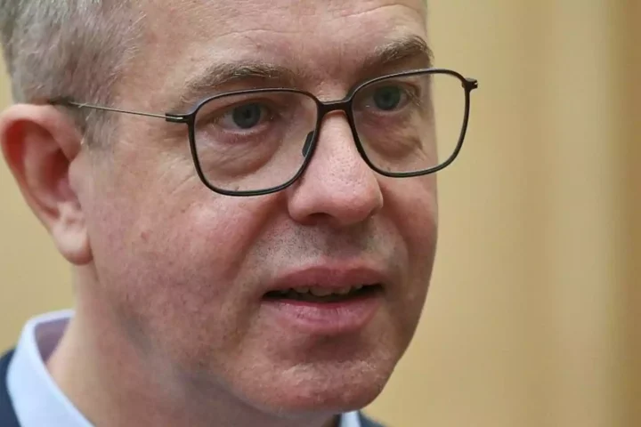 Nahaufnahme eines Mannes mit Brille vor hellem Hintergrund.