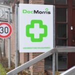 DocMorris-Logo an einem Gebäudeschild vor einem Eingang.