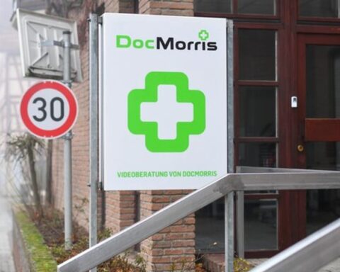 DocMorris-Logo an einem Gebäudeschild vor einem Eingang.