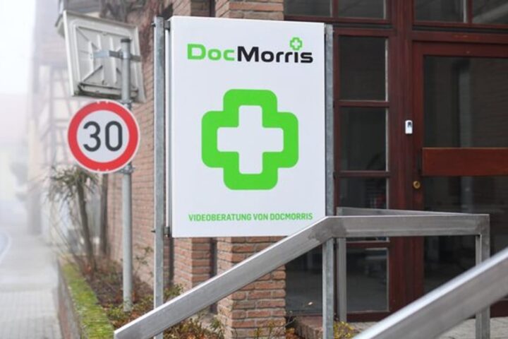 DocMorris-Logo an einem Gebäudeschild vor einem Eingang.