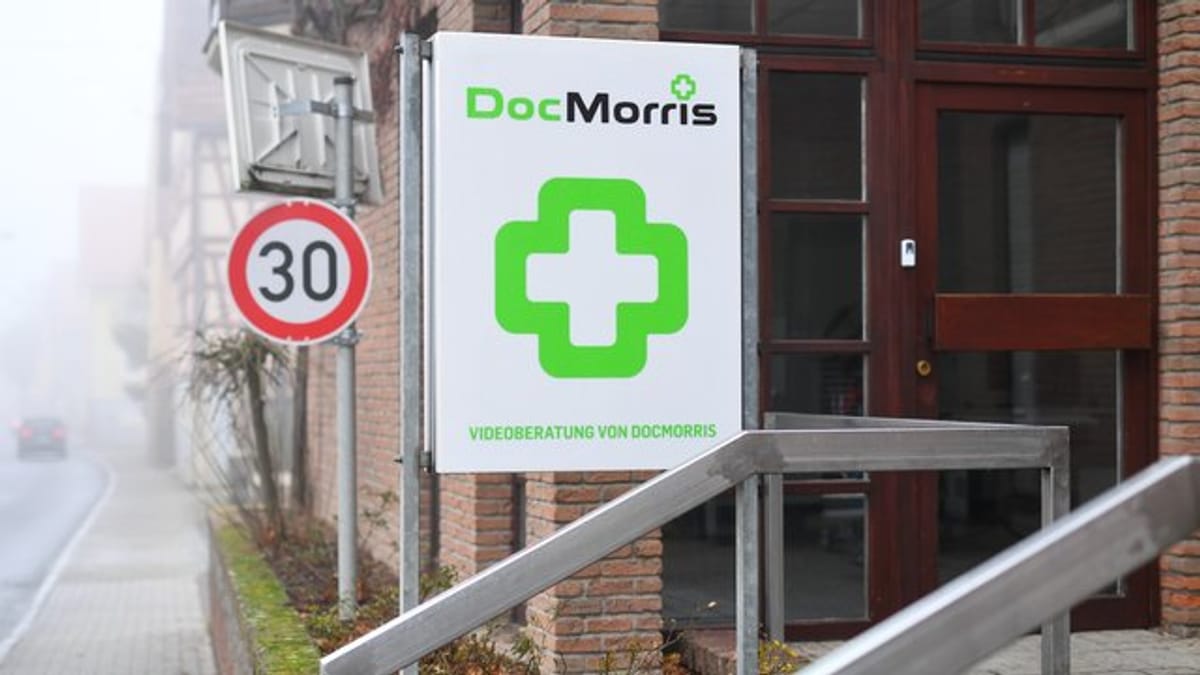 DocMorris-Logo an einem Gebäudeschild vor einem Eingang.