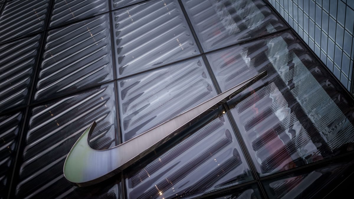 Nike-Logo an der Glasfassade eines Gebäudes.
