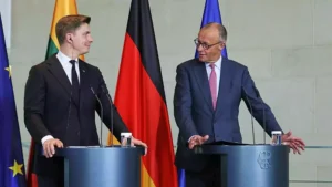 Zwei Politiker stehen an Rednerpulten vor EU-, Deutschland- und Litauen-Flaggen.