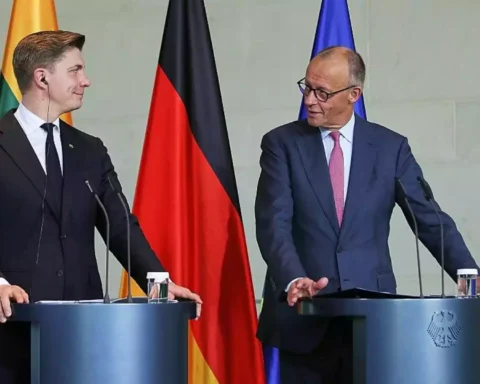 Zwei Politiker stehen an Rednerpulten vor EU-, Deutschland- und Litauen-Flaggen.