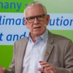 Jochen Flasbarth spricht vor einem grünen Hintergrund bei einer Klimaveranstaltung.