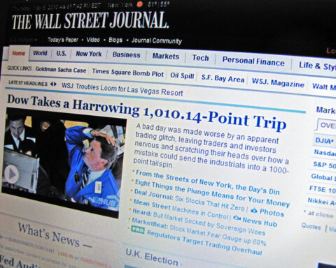 Foto einer Wall-Street-Journal-Webseite mit Börsenüberschrift und eingebettetem Bild eines Händlers am Handelsplatz.