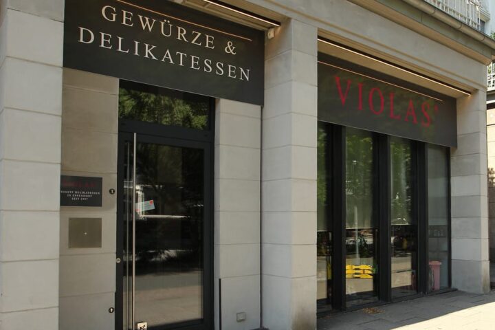 Außenansicht einer Violas'-Filiale mit Schild „Gewürze & Delikatessen“.