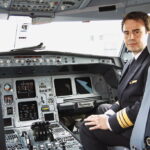 Ein Pilot sitzt im Cockpit eines Verkehrsflugzeugs.