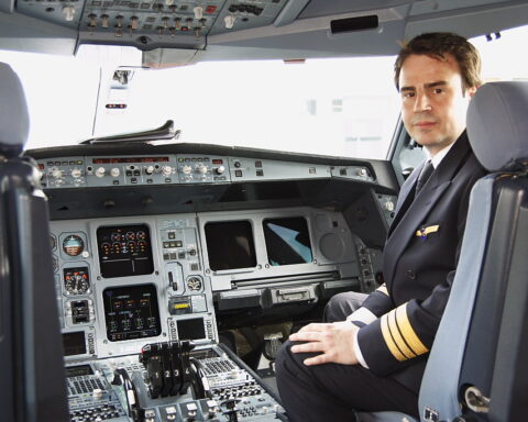 Ein Pilot sitzt im Cockpit eines Verkehrsflugzeugs.