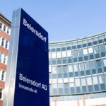 Beiersdorf-Standort mit Firmenschild vor Bürogebäuden.