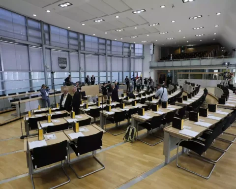 Blick in den Plenarsaal des Landtags von Sachsen-Anhalt mit vorbereiteten Sitzreihen und einigen Menschen im Saal.