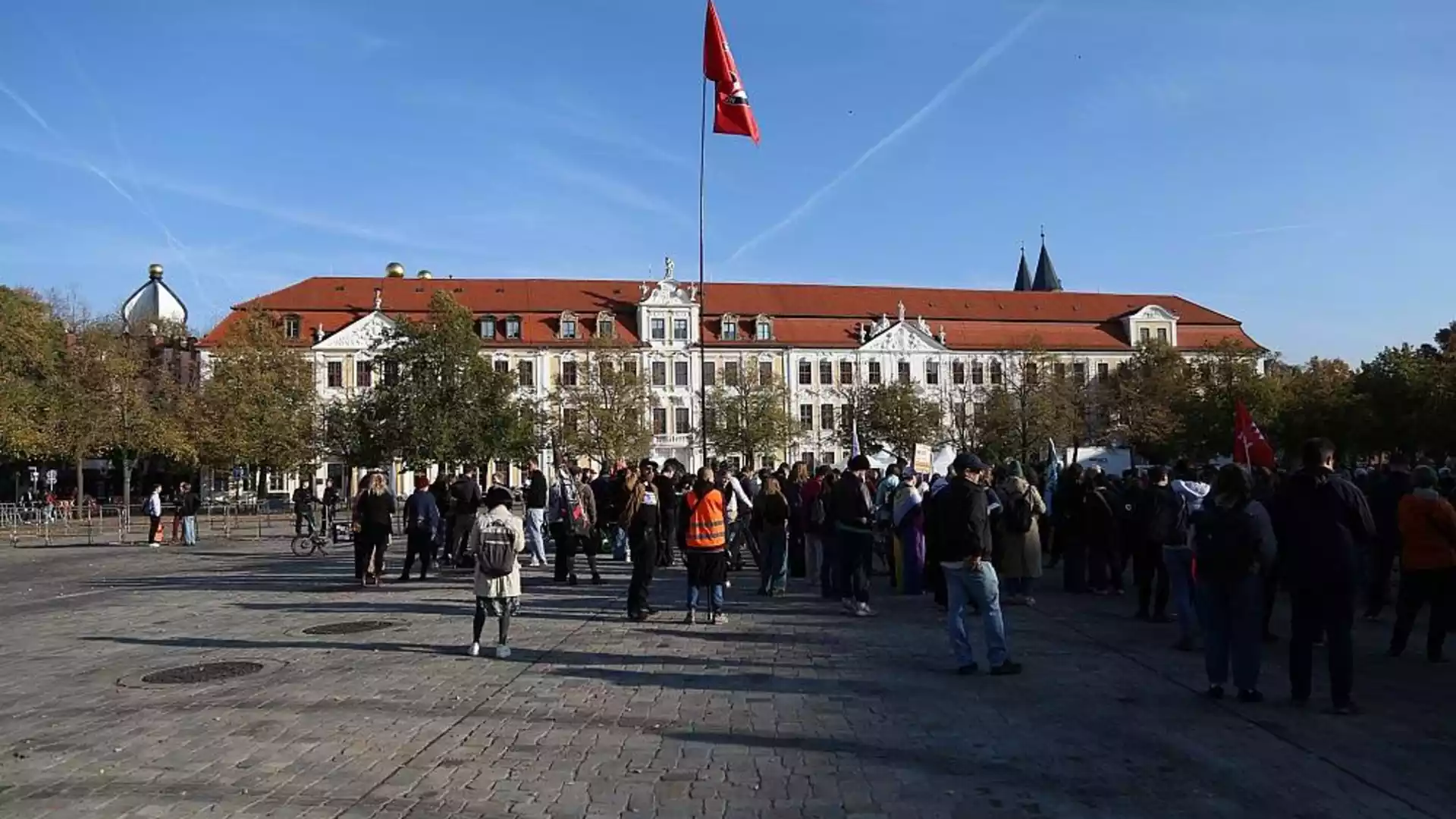 AfD nominiert Tobias Rausch für Landtagspräsidium in Sachsen-Anhalt 1 Menschen versammeln sich vor einem historischen Regierungsgebäude in Magdeburg mit roter Fahne auf dem Dach.