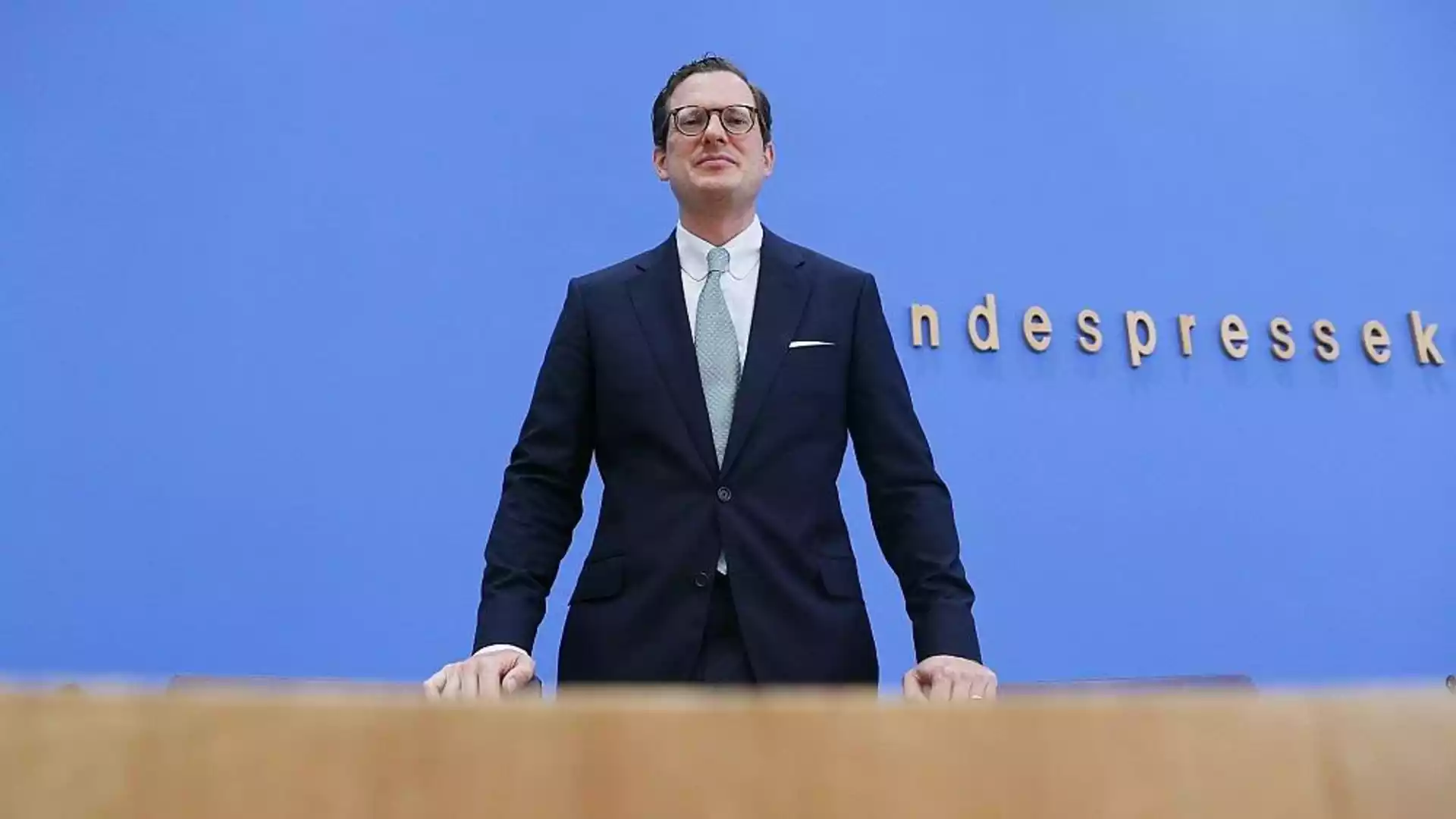 Hennemann warnt vor Aushöhlung des Informationsfreiheitsrechts 1 Moritz Hennemann steht vor blauem Hintergrund am Rednerpult bei einer Pressekonferenz.
