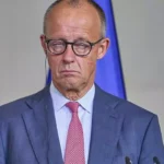 Friedrich Merz steht bei einem offiziellen Auftritt am Rednerpult.