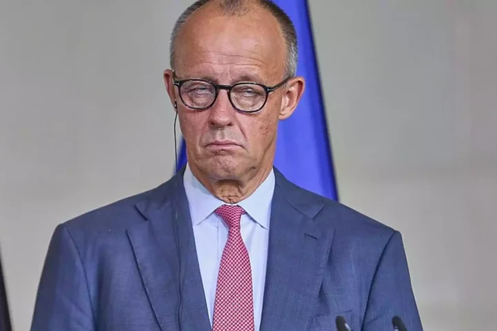 Friedrich Merz steht bei einem offiziellen Auftritt am Rednerpult.