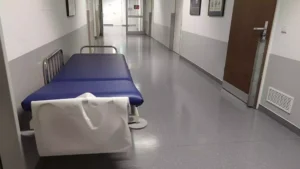 Leere Krankenhausflur mit Transportliege im Vordergrund.