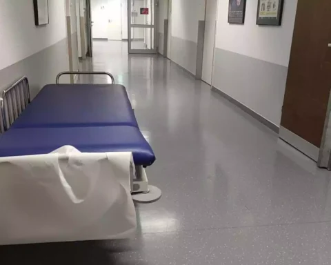 Leere Krankenhausflur mit Transportliege im Vordergrund.