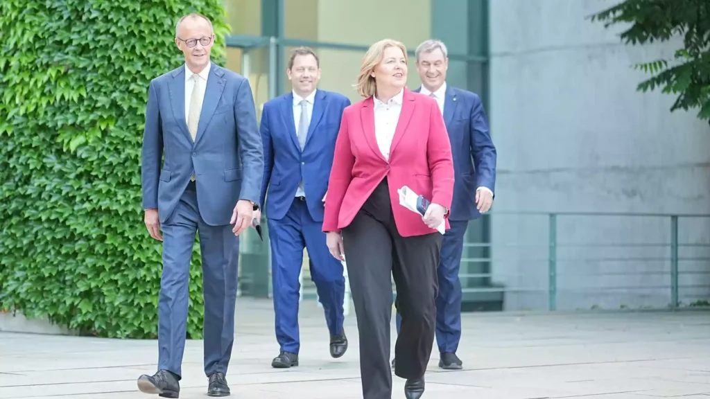 Mehrere Politiker gehen vor einem Regierungsgebäude aufeinander zu.