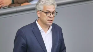 Ein Mann mit grauen Haaren und Brille im dunklen Anzug spricht im Plenarsaal.