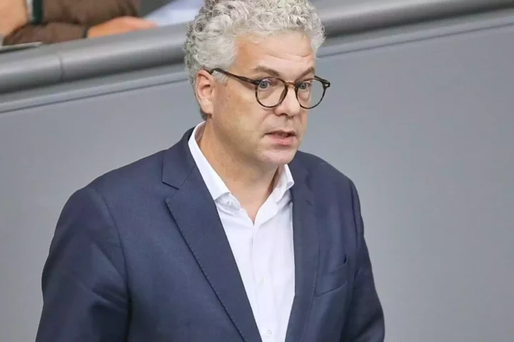 Ein Mann mit grauen Haaren und Brille im dunklen Anzug spricht im Plenarsaal.