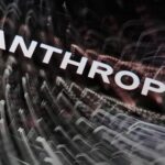 Schriftzug „ANTHROPIC“ vor abstrakten Lichtspuren.