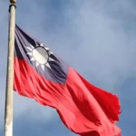 Taiwan-Flagge weht an einem Mast vor blauem Himmel.