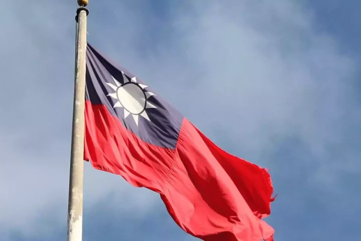 Taiwan-Flagge weht an einem Mast vor blauem Himmel.