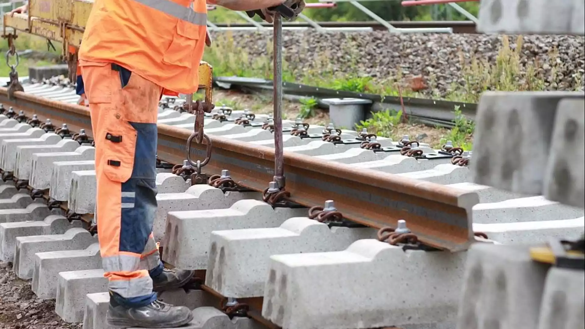 Bilger kritisiert 14-monatige Sperrung der Bahnstrecke Berlin-Hannover 1 Arbeiter in orangefarbener Schutzkleidung bei Gleisbauarbeiten an einem Bahnstreckenabschnitt.