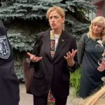 Karin Prien spricht im Freien mit mehreren Personen und gestikuliert dabei.
