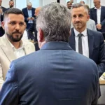 Mehrere Politiker stehen und sprechen in einem Sitzungssaal des Landtags.