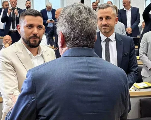 Mehrere Politiker stehen und sprechen in einem Sitzungssaal des Landtags.