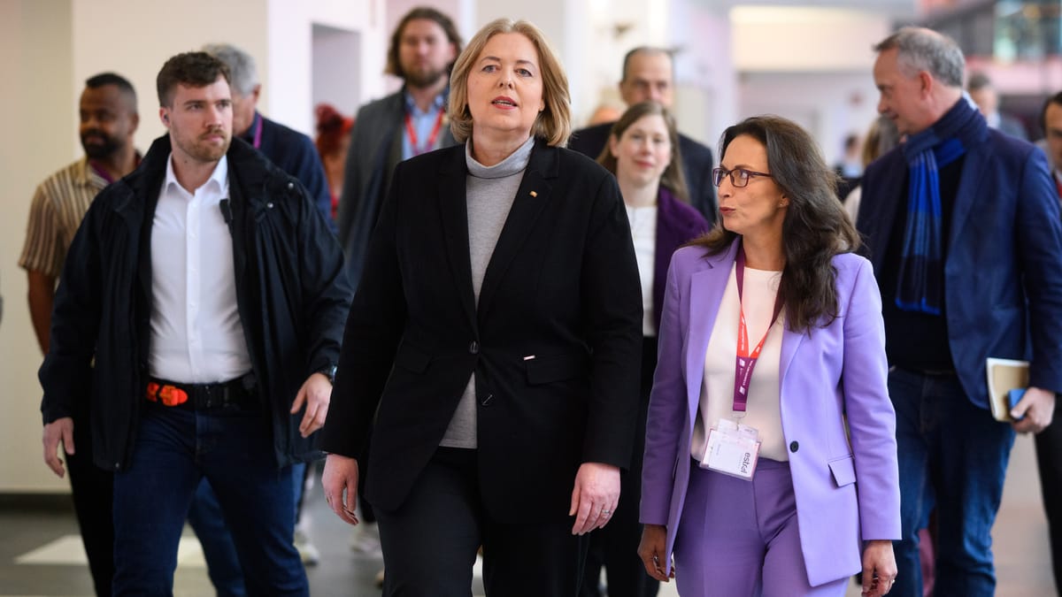 Streit um Betriebsrente bremst geplante Gespräche zwischen Gewerkschaften und Arbeitgebern 1 Mehrere Personen gehen in einem Innenraum, zwei Frauen im Vordergrund tragen Businesskleidung und Besucherausweise.