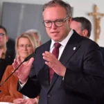 Mario Voigt spricht an einem Rednerpult vor mehreren Personen im Hintergrund.